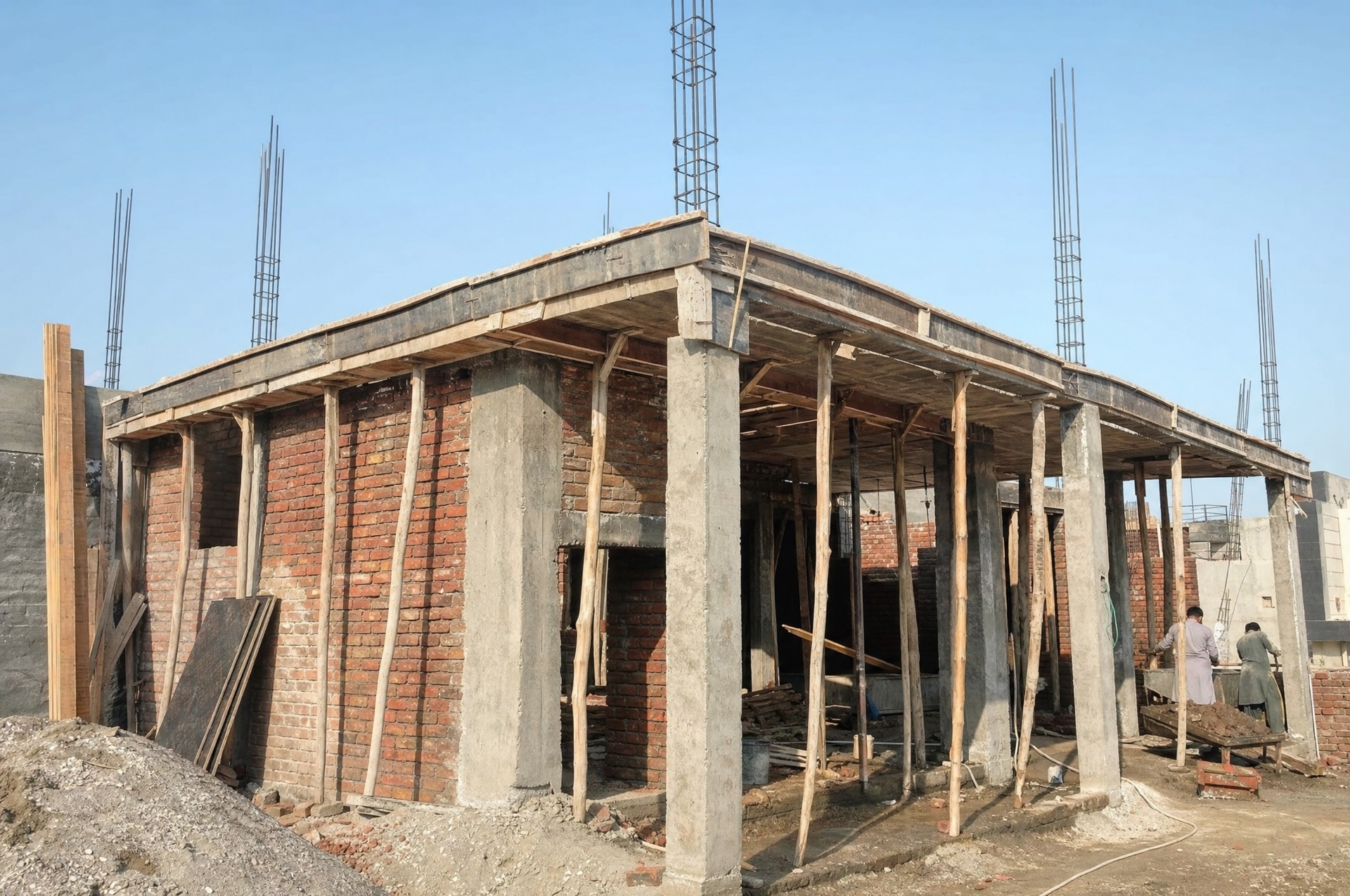 Grey structure under construction with brick walls and concrete columns